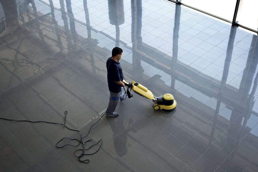 Operatore con lavasciuga professionale su un pavimento industriale